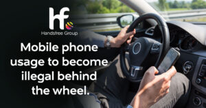 Image of a person driving with their phone in their hand. The text reads " Mobile phone usage to become illegal behind the wheel".