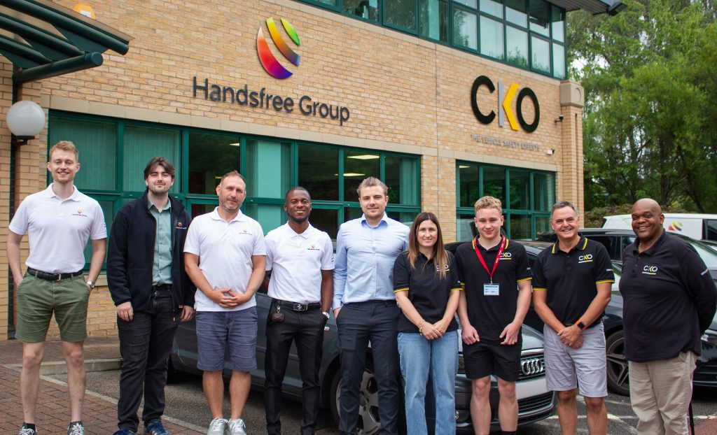 Image of Owen McMenamie with the team at Handsfree Group and CKO, stood in front of the Manchester office.
